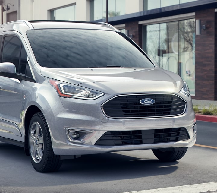 2023 Ford Transit Connect Passenger Wagon stopped at a crosswalk as pedestrian crosses the street