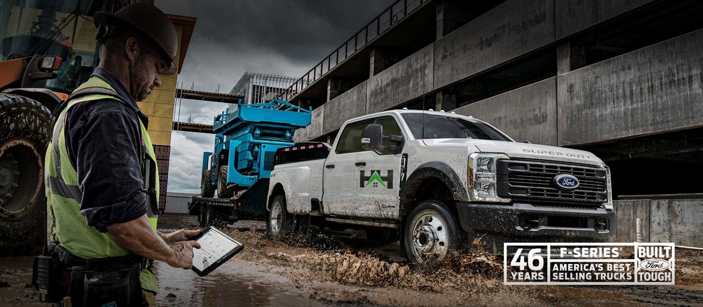 2023 Ford F-450® Super Duty® SuperCrew® Cab pulling a hydraulic lift on trailer through muddy water